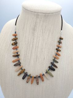 "This beautiful Boho necklace is designed with a mix of natural gemstones, Czech seed beads and dark brown leather cord. The gemstone mix includes Tiger's eye, Unakite and pink Aventurine. The length of the stone beads is 10 to 20mm. The gemstones have very nice matte finish. The necklace is 20.0 inches long. It's finished with silver plated lobster clasp and 2\" extender chain." Brown Adjustable Cord Jewelry For Healing, Unique Adjustable Brown Crystal Necklace, Unique Brown Adjustable Crystal Necklace, Earthy Necklace With Adjustable Cord For Healing, Brown Beaded Necklaces With Stones, Artisan Brown Crystal Necklaces With Natural Stones, Adjustable Brown Beaded Necklaces With Stones, Adjustable Brown Beaded Necklace With Stones, Adjustable Brown Hand-strung Necklaces