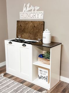 a white stove top oven sitting on top of a wooden cabinet next to a rug