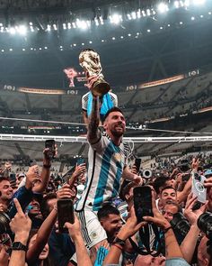 a man holding up a trophy in front of a crowd