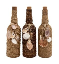 three wine bottles decorated with seashells and shells