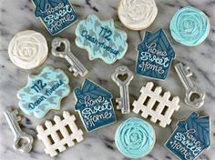 cookies decorated with blue and white icing are on a marble countertop next to keys