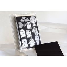 a black and white photo frame with various stickers on the front, in a clear plastic package