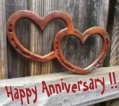 two heart shaped wooden pieces with the words happy anniversary