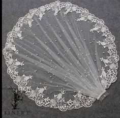 a white lace doily with flowers and pearls on the edge is shown in front of a gray background