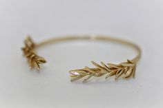 This unique and detailed rosemary leaves bracelet is perfect for a special occasion or to add a hint of a herb garden charm to just another everyday look. It's made out of two intricate rosemary branches soldered securely to a flexible wire base. It is flexible and easy to adjust. Rosemary signifies love, loyalty, happiness and remembrance * Bracelet diameter is approximately 15cm / 6inch. * Comes wrapped in a pretty organze gift bag. * Could be requested in either 14k gold, rose gold or silver Leaves Bracelet, Air Ionizer, Bridal Cuff, Silver Smithing, Rosemary Leaves, Organic Jewelry, Floral Bracelet, Leaf Bracelet, Gold Headband