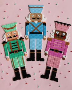 three pixelated toy soldiers are standing next to each other on a pink background with confetti