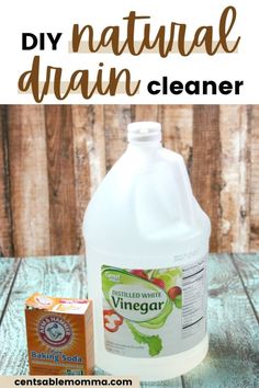 a bottle of vinegar cleaner next to a carton of vinegar on a wooden table