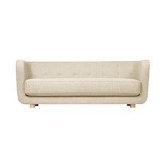 a white couch sitting on top of a wooden table