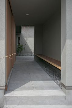 an empty hallway with concrete steps leading up to the door and planter in the corner