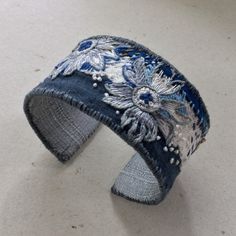 a denim cuff with embroidered flowers on it