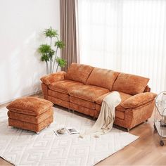 a living room with a couch, ottoman and chair in the corner next to a window