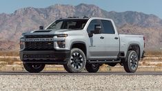 a silver chevrolet truck is parked in the desert