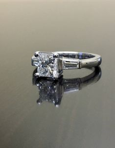 a diamond ring sitting on top of a reflective surface