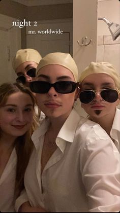 three women in white shirts and black sunglasses are posing for the camera with their heads wrapped around each other