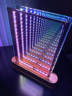 an illuminated display case sitting on top of a wooden table next to a purple light