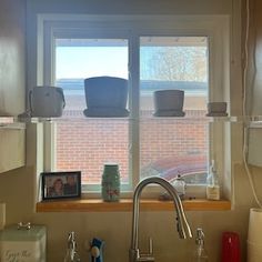 a kitchen sink under a window next to a faucet