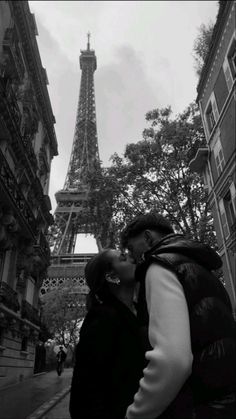 a couple kissing in front of the eiffel tower