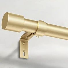 an image of a telescope mounted on the side of a white wall with gold hardware