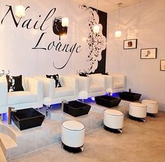 a room with white couches and chairs in front of a wall that says nail lounge