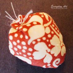 a red and white fabric bag with an animal design on it's side, sitting on a black surface