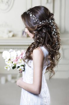 a woman with long hair holding flowers in her hand