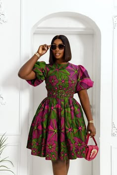 Look amazing and feel confident in the BUNMI midi dress! This African print design features puff sleeves, ensuring you'll be an eye-catching sight no matter where you go. Whether you want to make a statement in the spotlight or elevate your style at work or a special event, this dress promises to have you looking your best.   FEATURES. * 100% African Wax Cotton * Midi dress with puff sleeve shoulder * Dress is Lined. * Back Zipper, Detachable belt included. * Side pockets * Dress is 43'' long * Model Is Wearing A Size Medium and 2X-Large  CARE INSTRUCTION * Hand Wash in Cold Water. * Do Not Bleach. * Press with Cool Iron on The Wrong Side Woman African Dresses, African Print For Work, Puff Sleeve African Dress, Wax Print Dresses Ankara Styles, Puff Sleeve Ankara Dress, Modest African Dresses For Women, Simple Kitenge Dress Design, A Line Ankara Dress, African Print Dresses Designs Classy