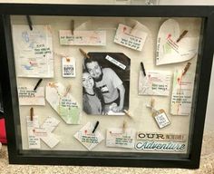 a framed photo with many different pieces of paper pinned to it