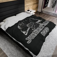 a bed with a black and white blanket on top of it