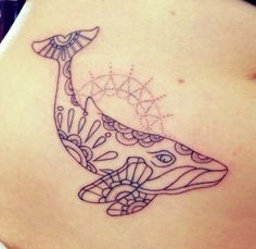 a woman's stomach with a tattoo design on the side of her belly and an image of a whale