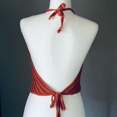 a white mannequin with an orange halter top on it's neck