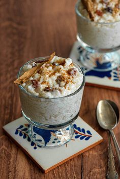 two desserts are sitting on small plates with spoons