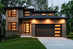 a large house with two garages and lights on