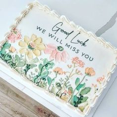 a cake decorated with flowers and the words good luck we will miss you on it