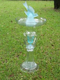 a glass vase sitting on top of a lush green field