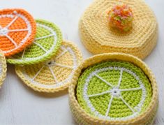 crocheted fruit coasters are sitting on a table