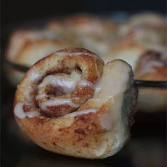 cinnamon rolls with icing sitting in glass dishes