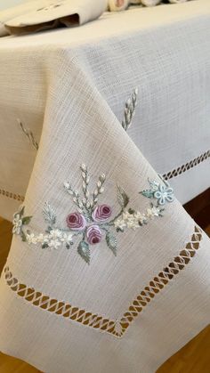 an embroidered tablecloth with flowers on it