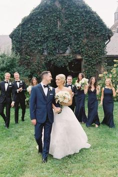 a bride and groom walking with their bridal party