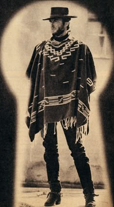 an old photo of a man with a hat and cape standing in front of a keyhole