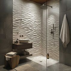 a bathroom with a shower, sink and towel hanging on the wall next to it