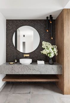 a bathroom with a sink, mirror and vase