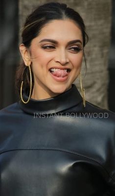 a woman wearing large hoop earrings and black leather jacket