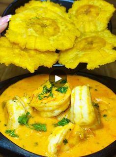 a bowl filled with yellow food next to two pieces of bread