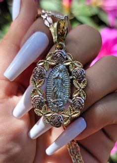 Celebrate her everlasting love with this beautiful Virgin Mary Blossom pendant. The beautifully detailed blossoms around her create a timeless bond of love and affection. This delicate piece makes a beautiful gift option that is sure to make an impression on all your friends and family! Pendant Height: 1.5" inches Includes tri-color 20" inch chain 14K Tri-color Gold Plating Tri-color charm and chain Keepsake Rose Gold Charms Jewelry, Rose Gold Pendant Jewelry Gift For Mom, Rose Gold Pendant Jewelry For Mother's Day, Spiritual Rose Gold Jewelry Gift For Her, Oval Pendant Keepsake Charm Jewelry, Gold Keepsake Jewelry With Large Pendant, Rose Gold Medallion Jewelry With Charms, Spiritual Rose Gold Medallion Jewelry, Silver Oval Pendant With Birth Flower