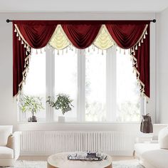 a living room with white furniture and red curtains