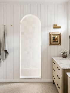 a white bathroom with an arched shower door