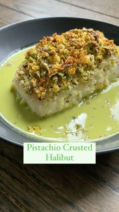 a piece of fish covered in green sauce on a plate with the words pistachio crusted halibut