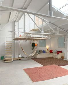 a living room filled with furniture and a hammock hanging from the ceiling