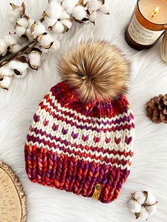 a knitted hat with a pom - pom sitting on top of it