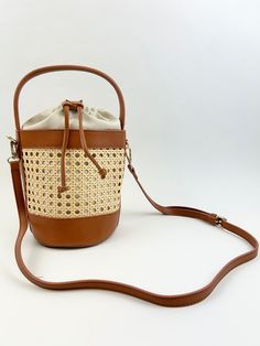 We love a bucket bag to carry all our essentials, and this woven rattan bag is the perfect bag to carry around all summer long! Product Details Material: Vegan Leather & Rattan Size: 11"L x 9"W Handle and Crossbody Strap Features a drawstring closure Baby Keepsakes, Rattan Bag, Sorority Gifts, Woven Rattan, Capri Blue, St Thomas, Perfect Bag, Clutch Wallet, Accessories Necklace